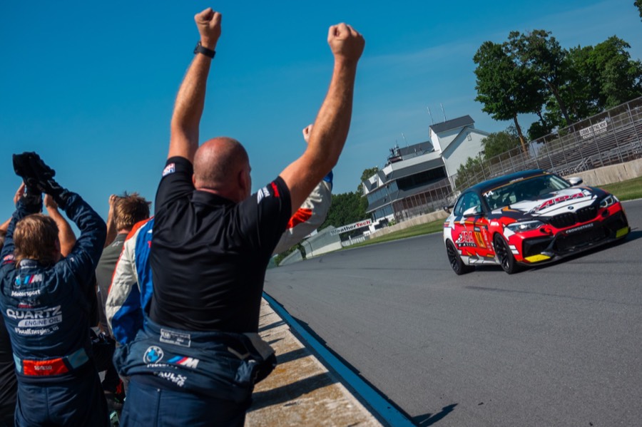 Crew celebrating on the pit wall as Ren's car passes