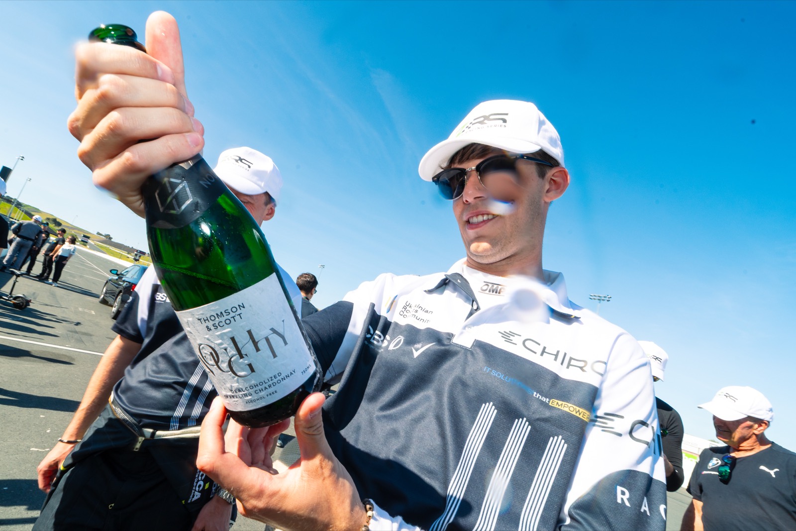 Ren celebrating with champagne in his Chiron team suit